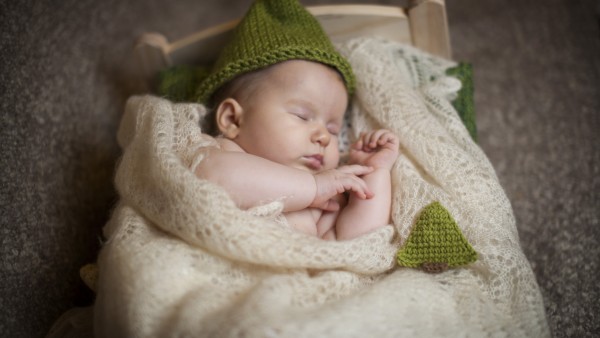 Обои спящего малыша в зеленой шапочке