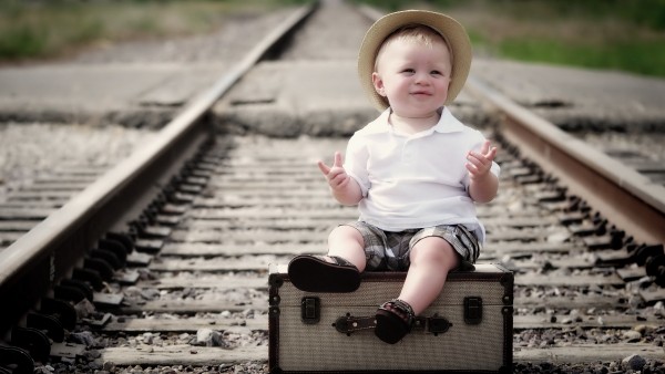 Ребенок на чемоданах на железнодорожных рельсах