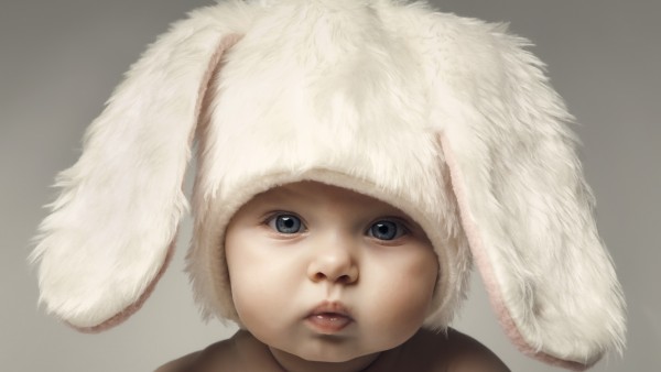 Ребенок в шапке кролика надул щеки скачать обои