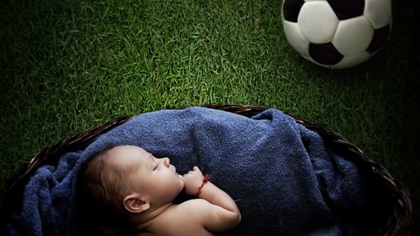 Спящий ребенок на футбольном поле обои