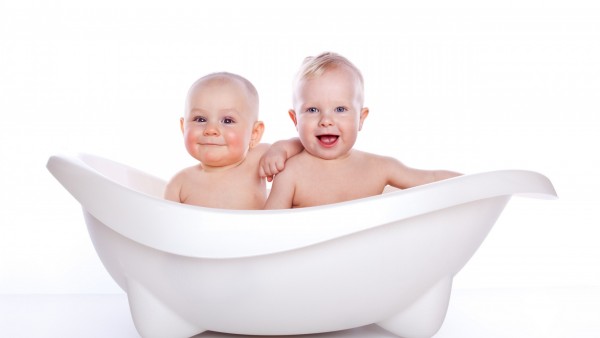 Маленькие детки братья в маленькой белой ванне 