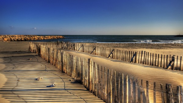 Фото песчаного побережья с каменными выступами