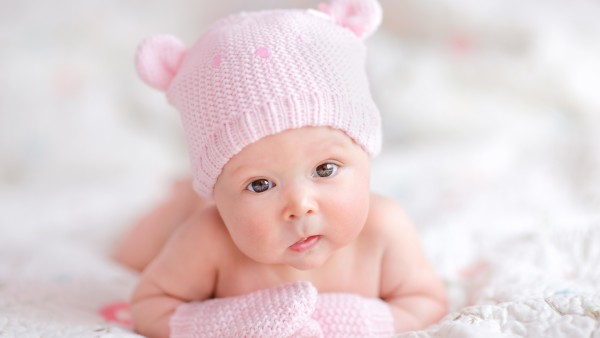 Маленький ребеночек в шапочке с ушками и перчаточках