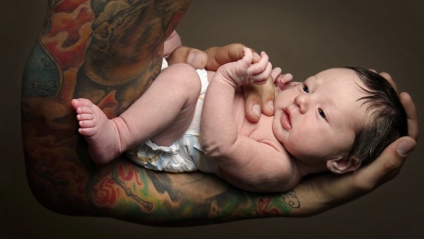 Фото младенца на накаченой татуированной руке
