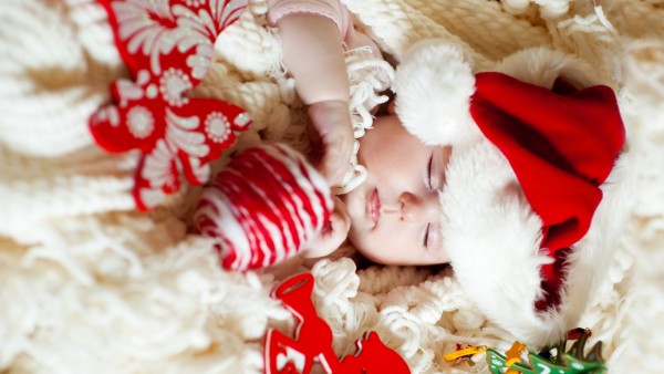 Маленький младенец спит в рождественской шапочке