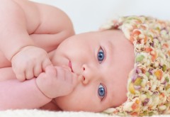 Маленький младенец смотрит голубыми глазками