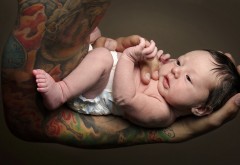 Фото младенца на накаченой татуированной руке